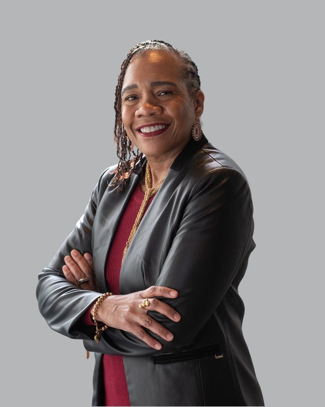 Angela Pitter, founder and CEO of LiveWire Collaborative, arms crossed, smiling